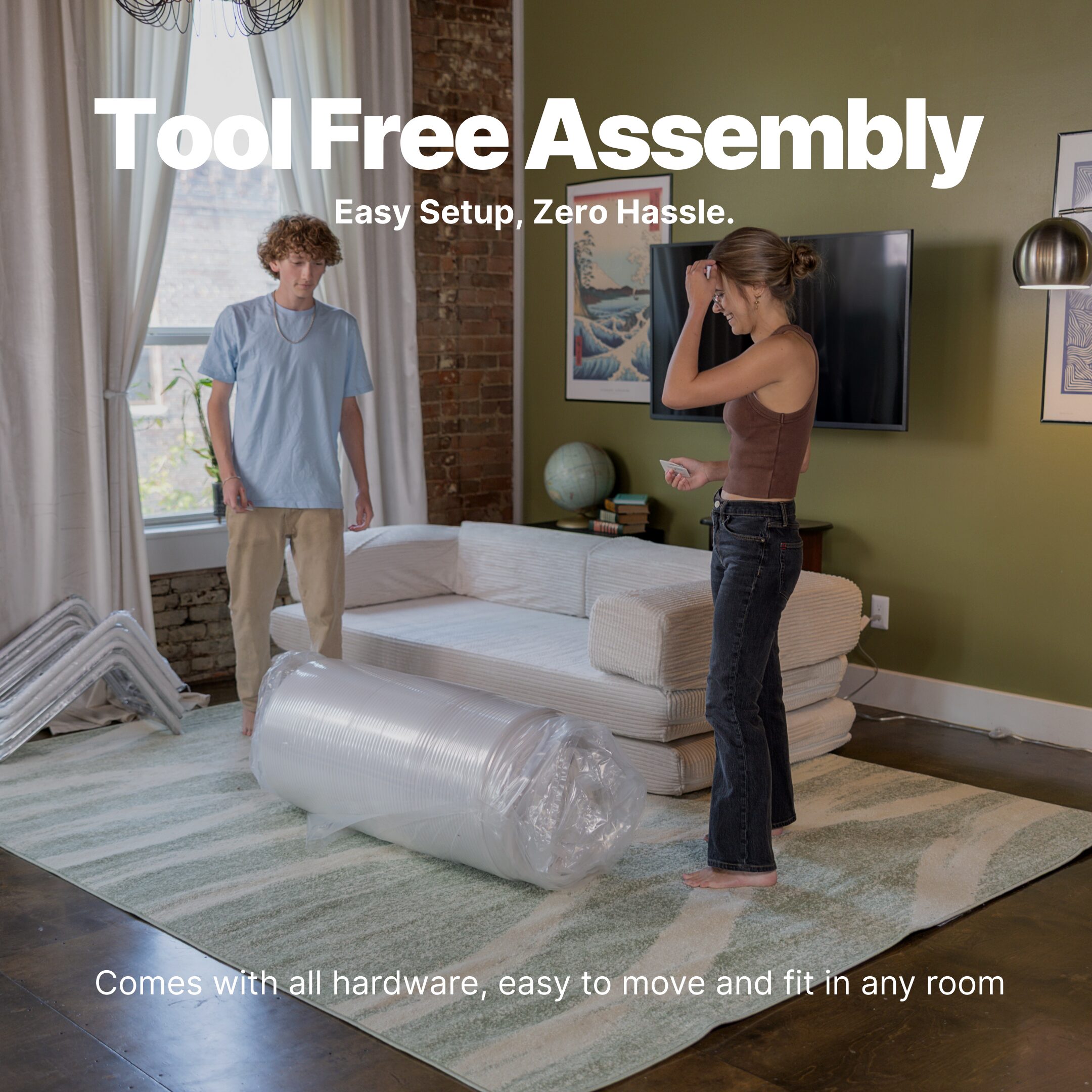 Photo of a young man and young woman unpacking a couch in a box with white text on the top that says "Tool Free Assembly."