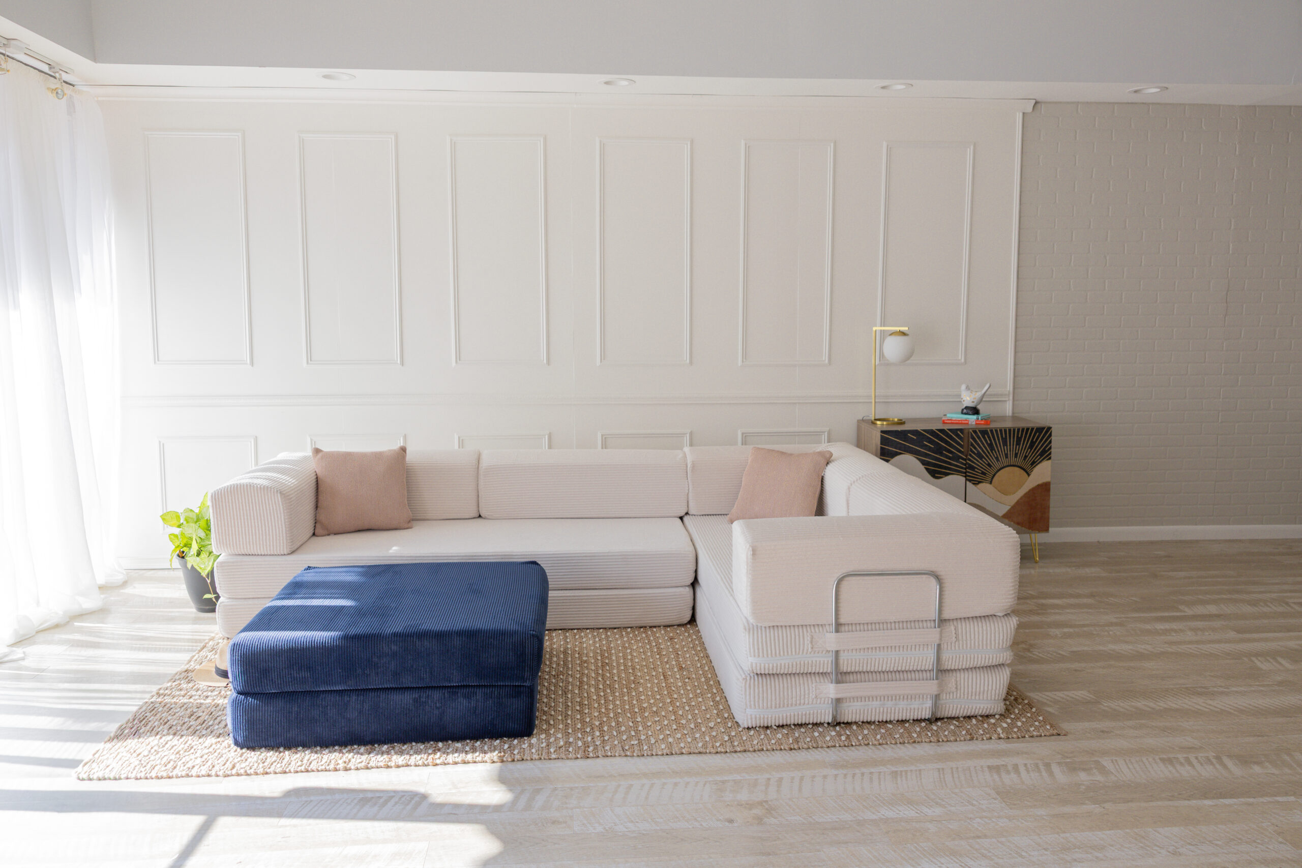 Large L Shaped couch with blue ottoman.