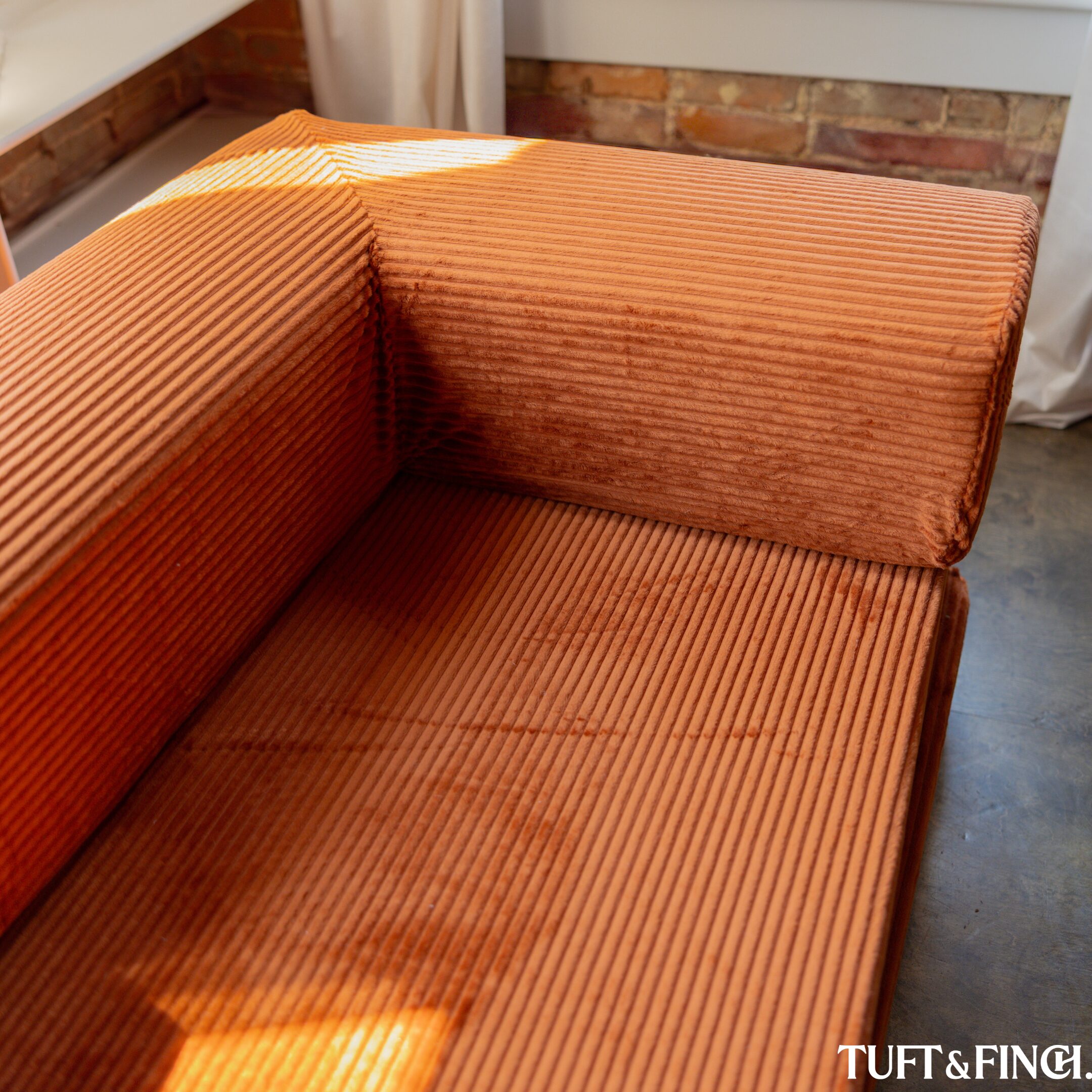 End of a saffron colored couch.