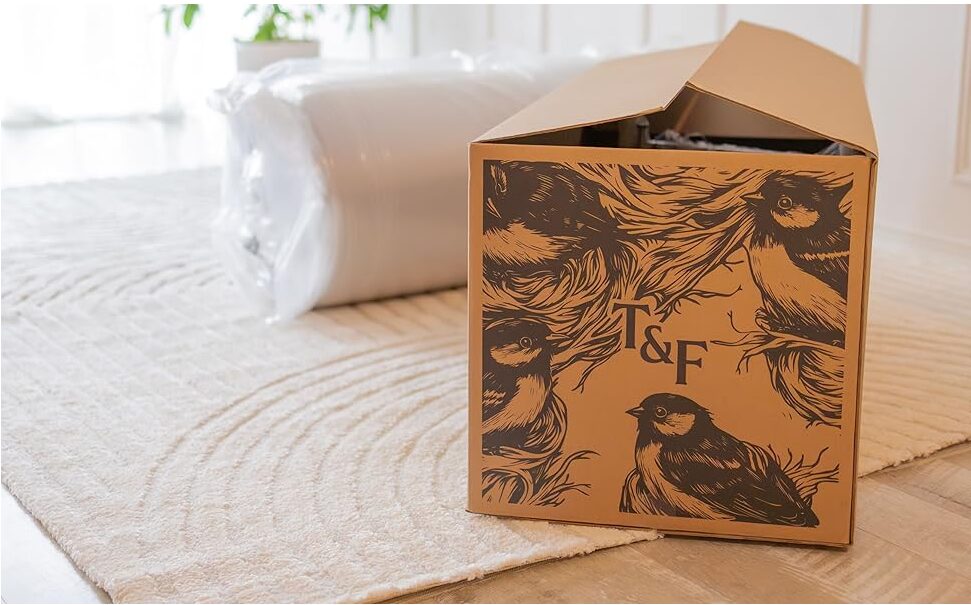 Image of Tuft & Finch box with rolled up couch behind it.