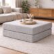 Grey modular ottoman with coffee and book sitting on it.