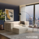 Cream boneless couch inside high rise apartment living room with cream boneless ottoman.