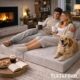 Modular ottoman folded out with couple and dog resting on it in living room.