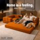 Family sitting on orange boneless sofa in expandable configuration.