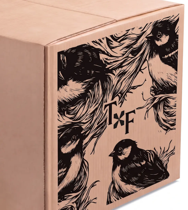 Image of cardboard box that boneless sofa's arrive in. Card board box has images of birds and Tuft and Finch logo on the side in black ink.